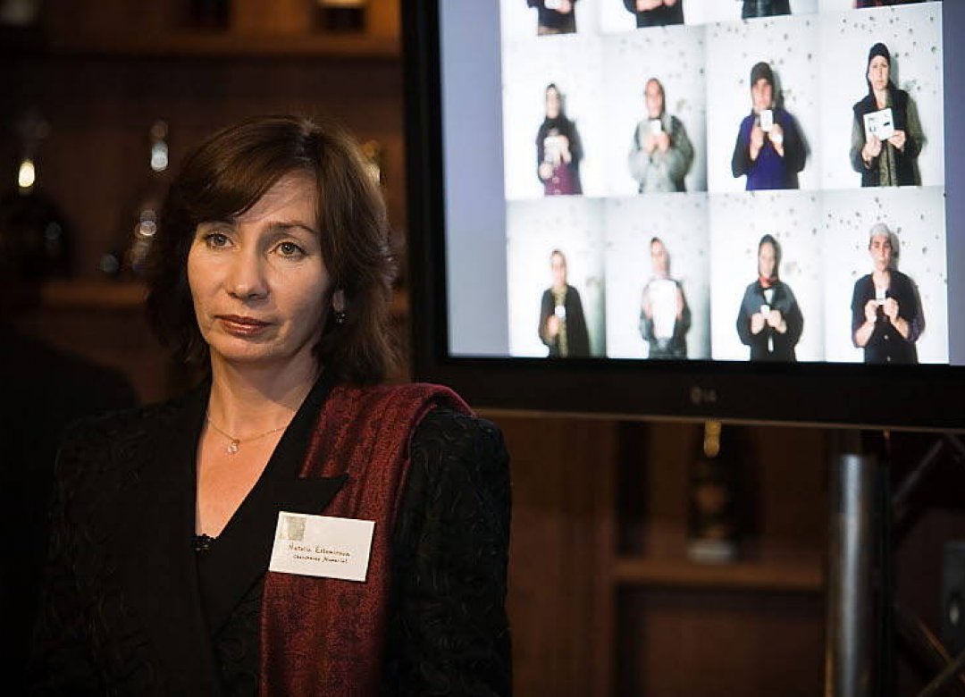 Наталья Эстемирова на фоне фотографий женщин, чьи родственники исчезли в Чечне.